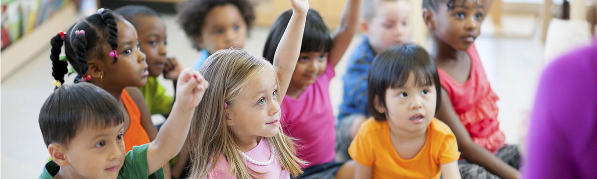 Young children sitting on floor in classroom