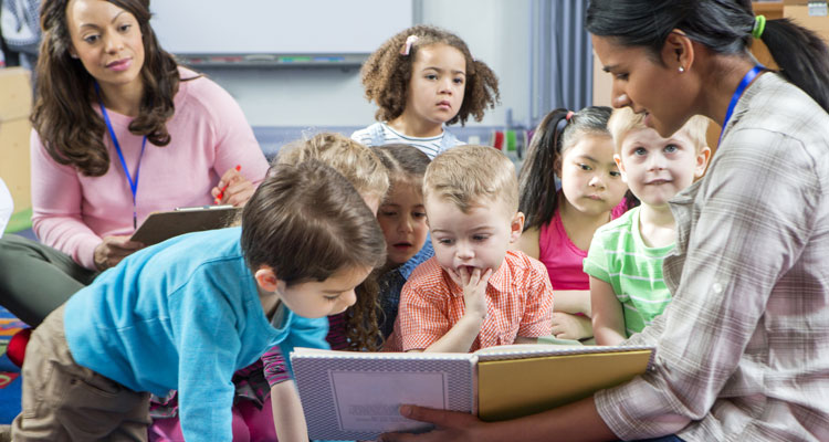 Storytime at Nursery, worker reading book to a number of toddlers